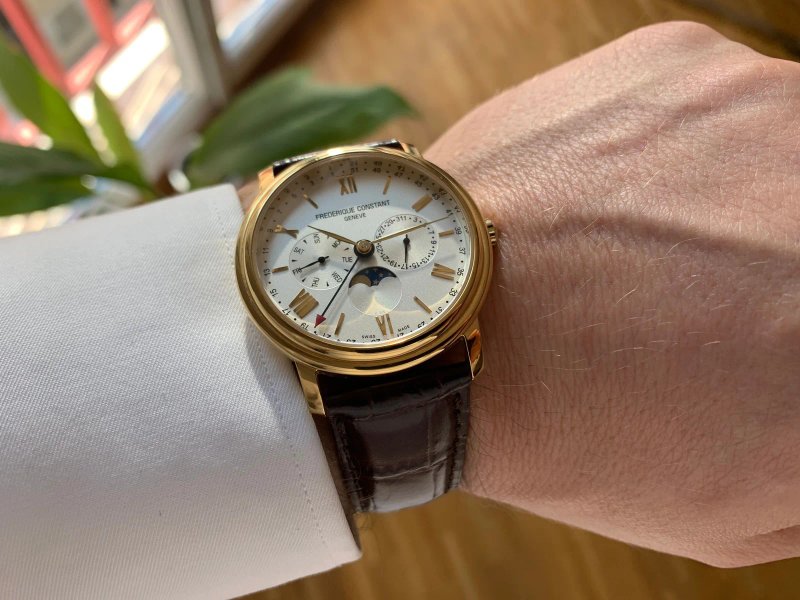 Gros plan d’une montre portée au poignet avec un arrière-plan urbain flou.